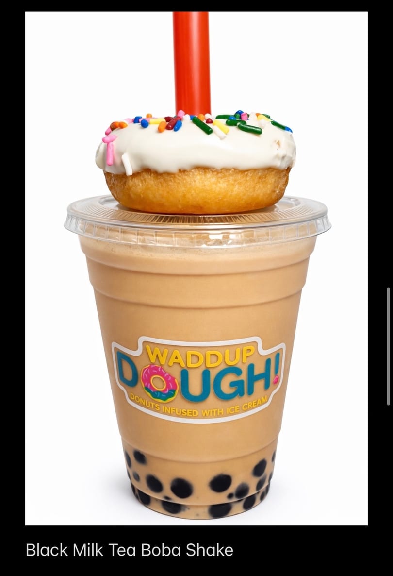 Waddup Dough! Black Milk Tea Boba Shake with a white-frosted, sprinkle-covered donut on top.