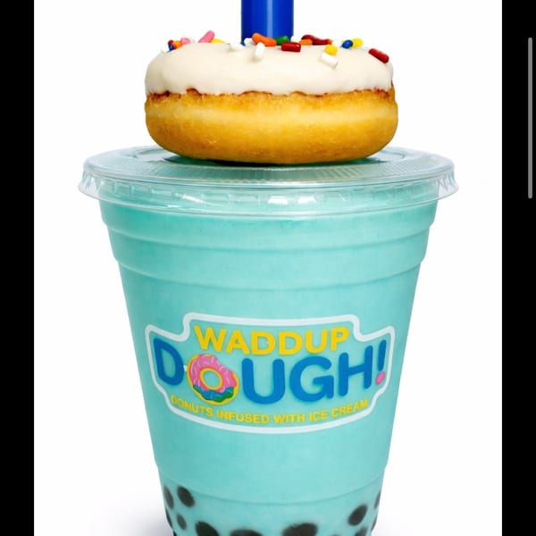 Blue Hawaii Boba Shake with a white-frosted, sprinkle-covered donut on top, and a blue straw.