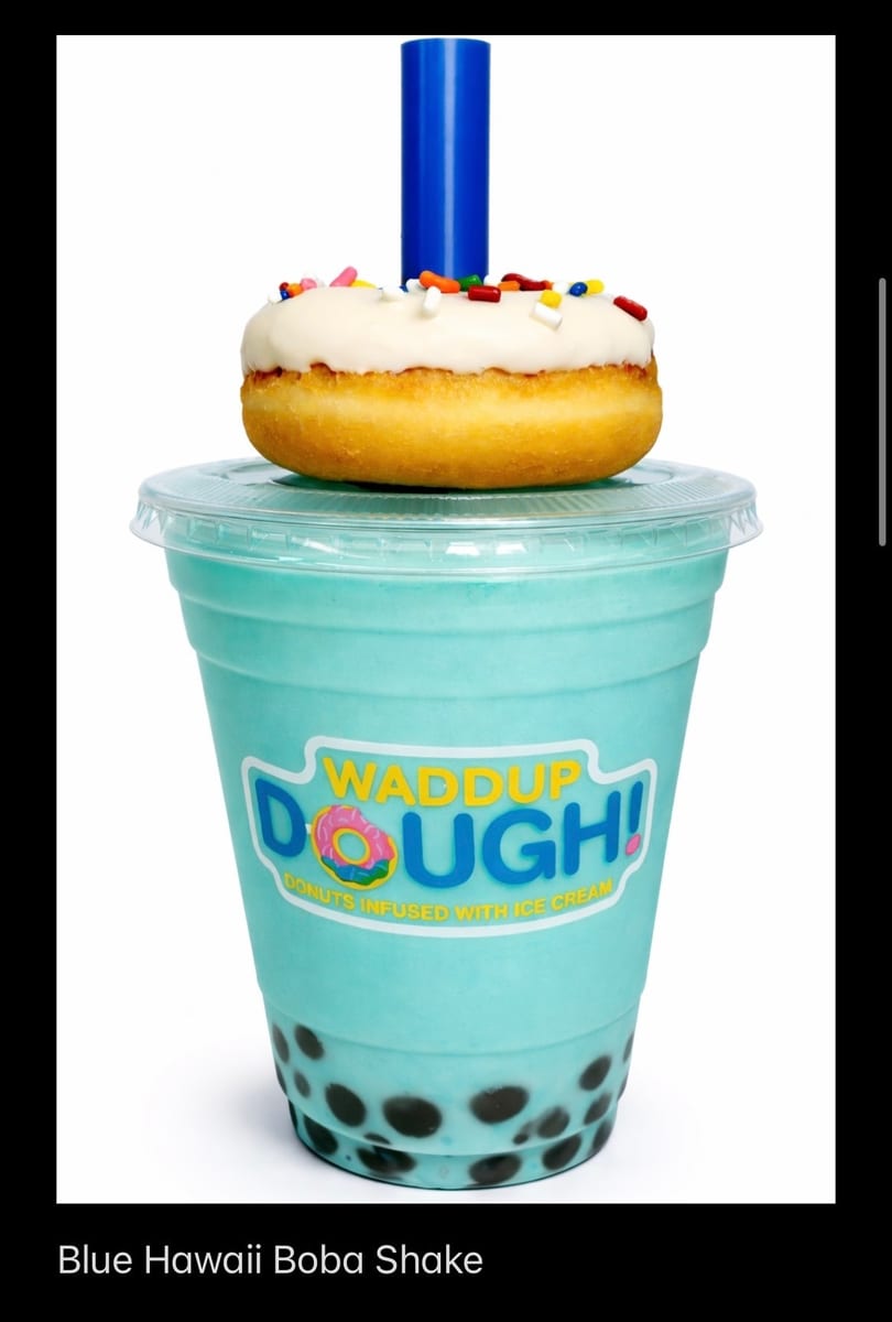 Blue Hawaii Boba Shake with a white-frosted, sprinkle-covered donut on top, and a blue straw.
