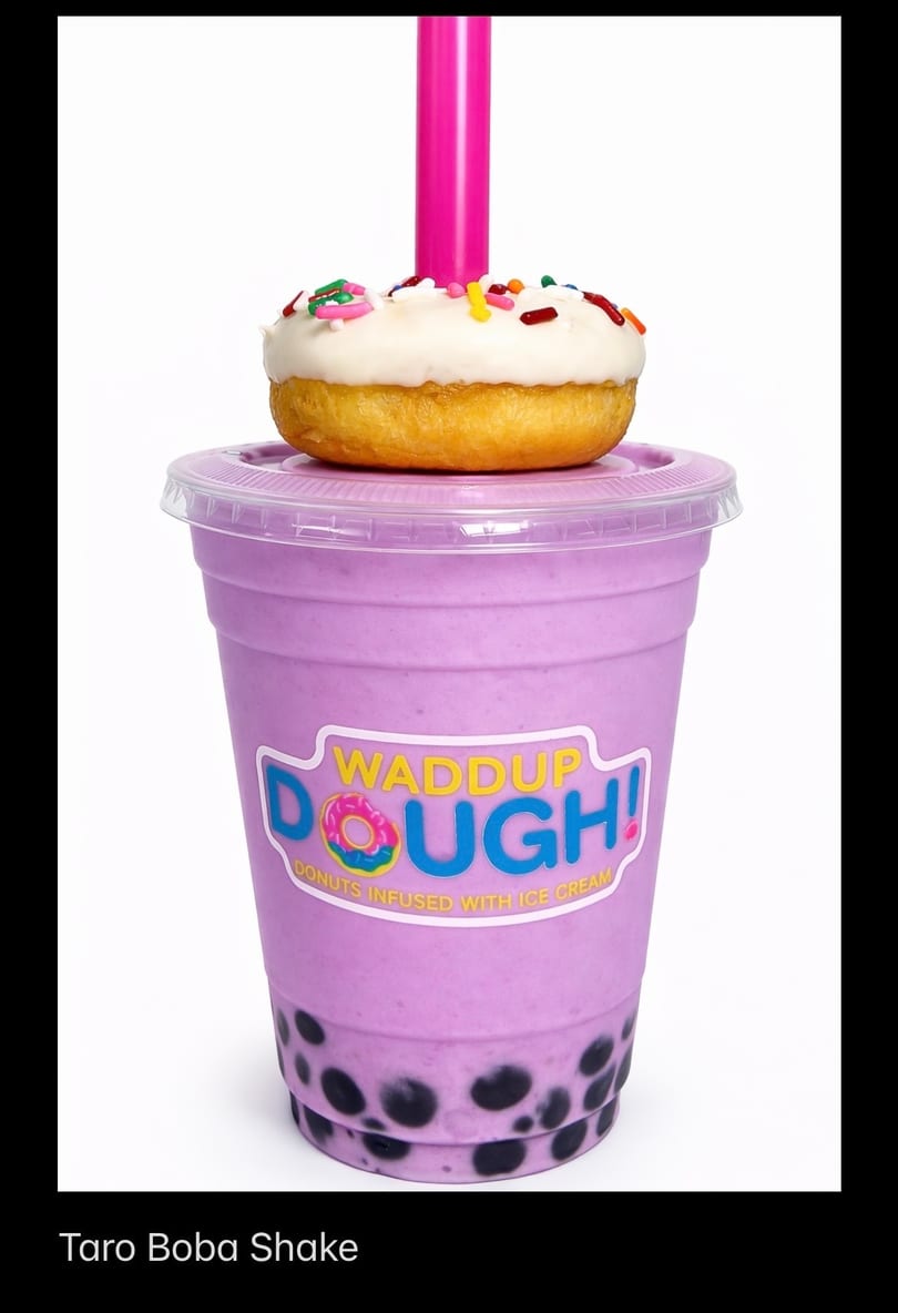 Taro boba shake with a white-frosted, sprinkle-covered donut on top, and a pink straw.